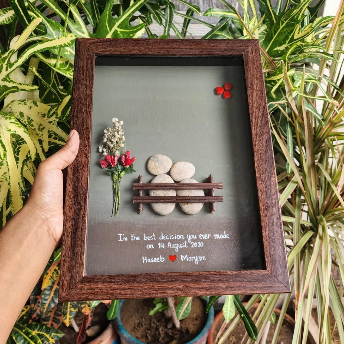 Framed 3D art with stones on a bench and romantic handwritten text.