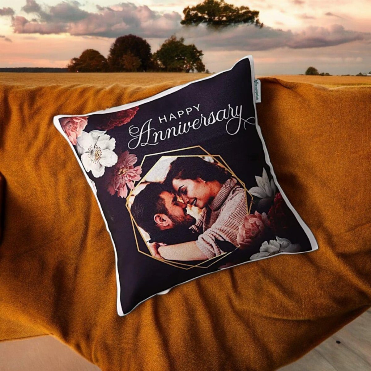 Decorative anniversary pillow with a couple's photo resting on a yellow blanket.