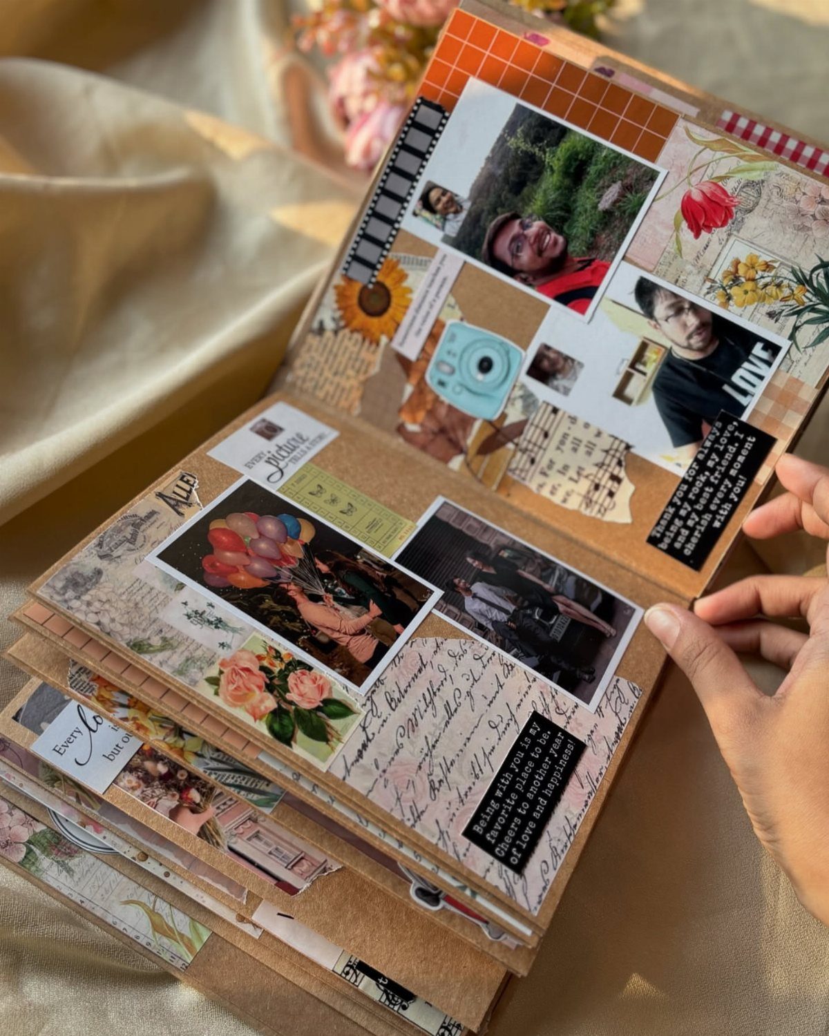 Open handmade scrapbook with couple photos, floral decorations, and handwritten notes on pages.
