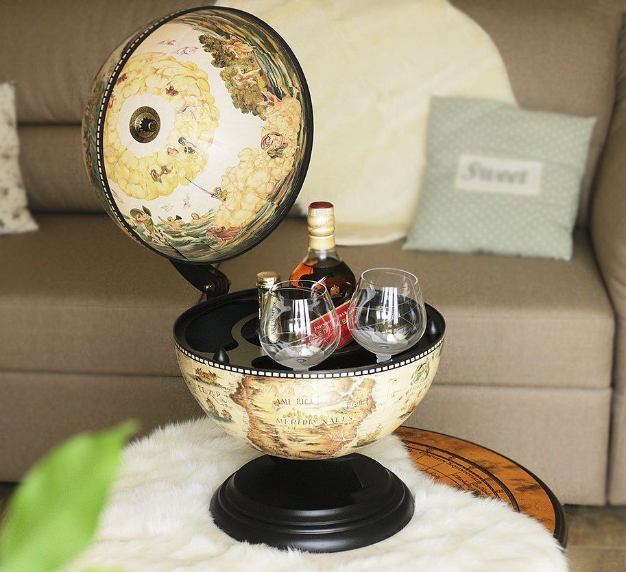 Vintage globe bar opened to show a liquor bottle and two glasses inside.