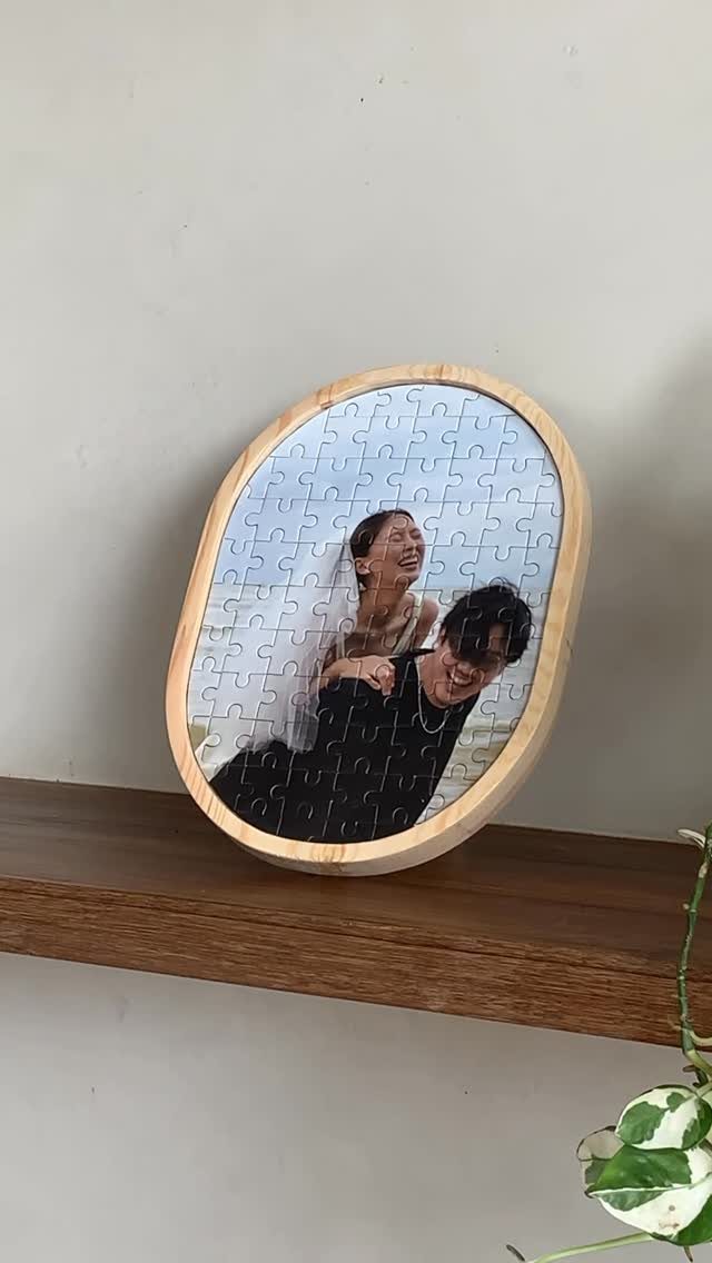 Custom jigsaw puzzle of a couple in an oval wooden frame on a shelf