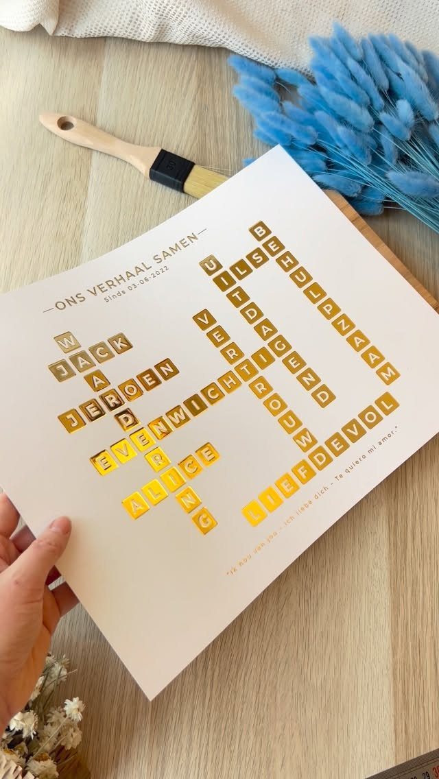 Custom crossword puzzle wall sign with gold lettering held over a wooden table.