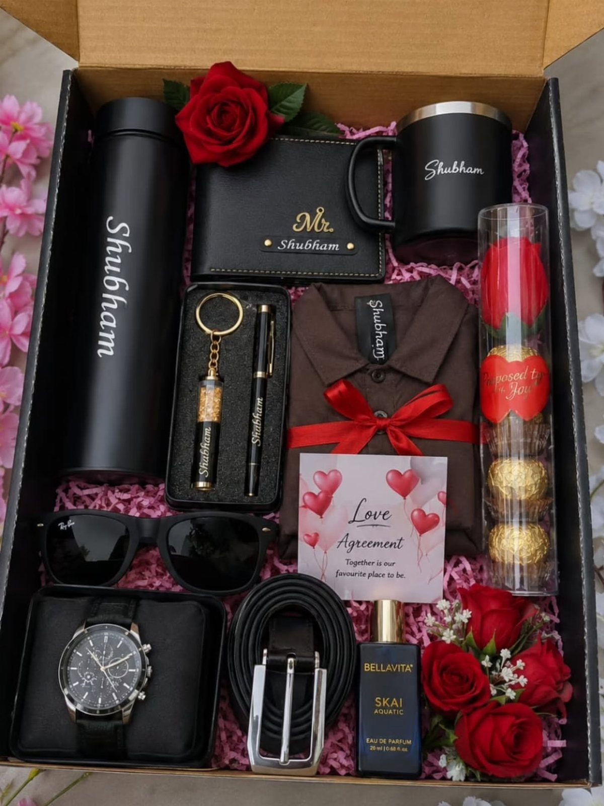 Personalized men's gift box with black accessories, red roses, and a love agreement card.