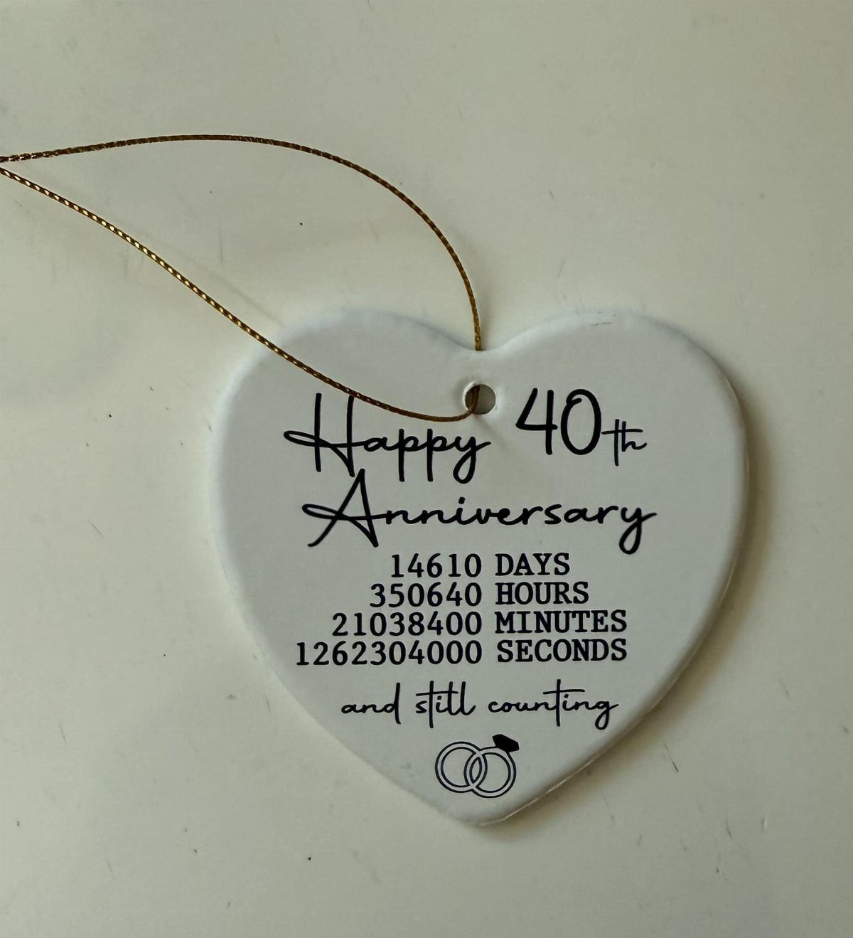 Heart-shaped ceramic ornament celebrating a 40th anniversary with time calculations and rings.