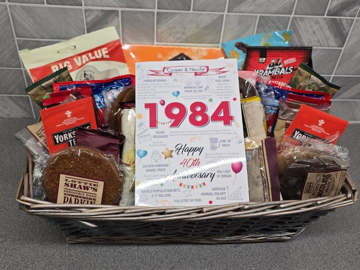 Wicker gift basket with snacks and a card celebrating a 40th anniversary.