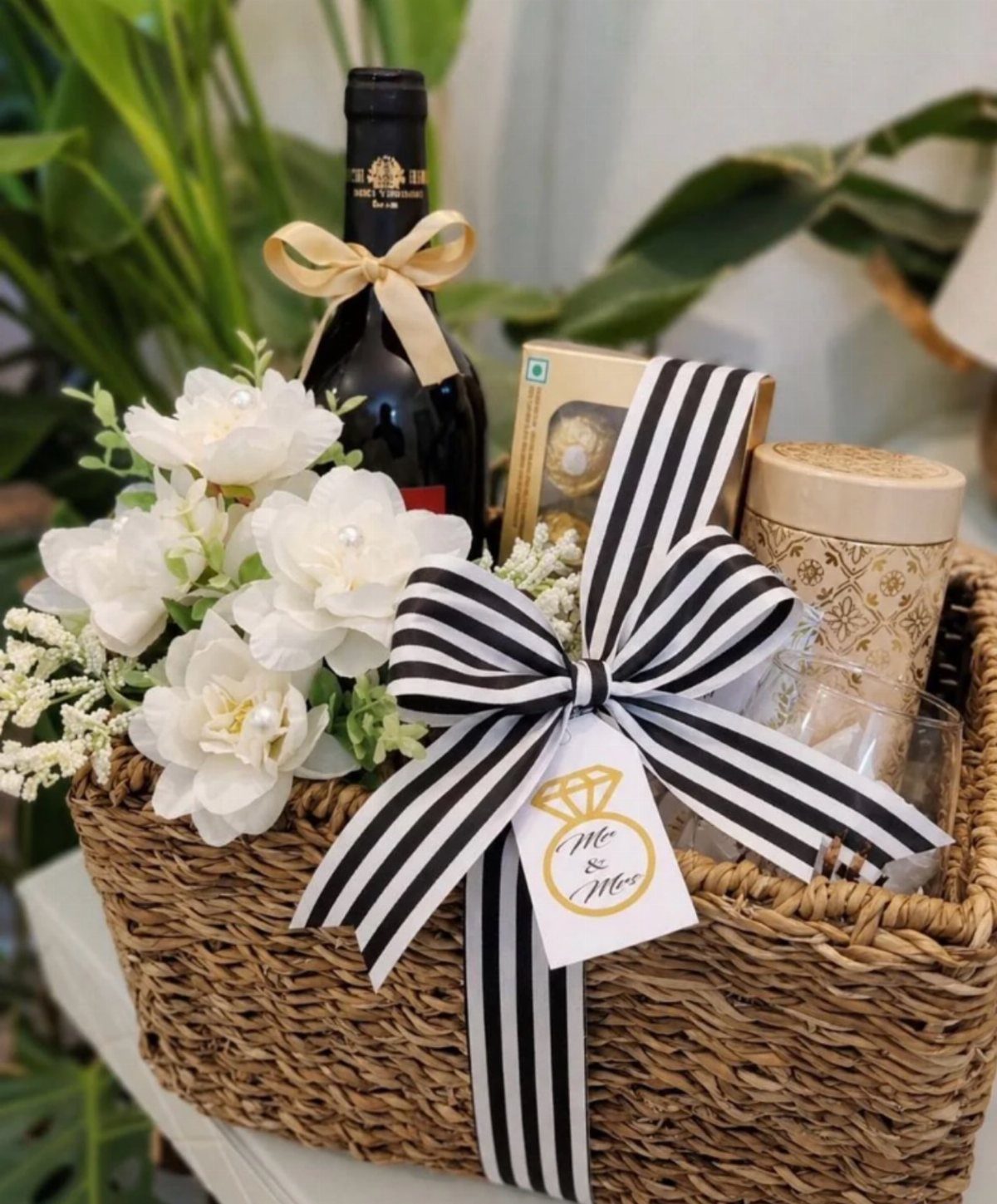 Wicker gift basket with wine, white flowers, and a Mr and Mrs tag.