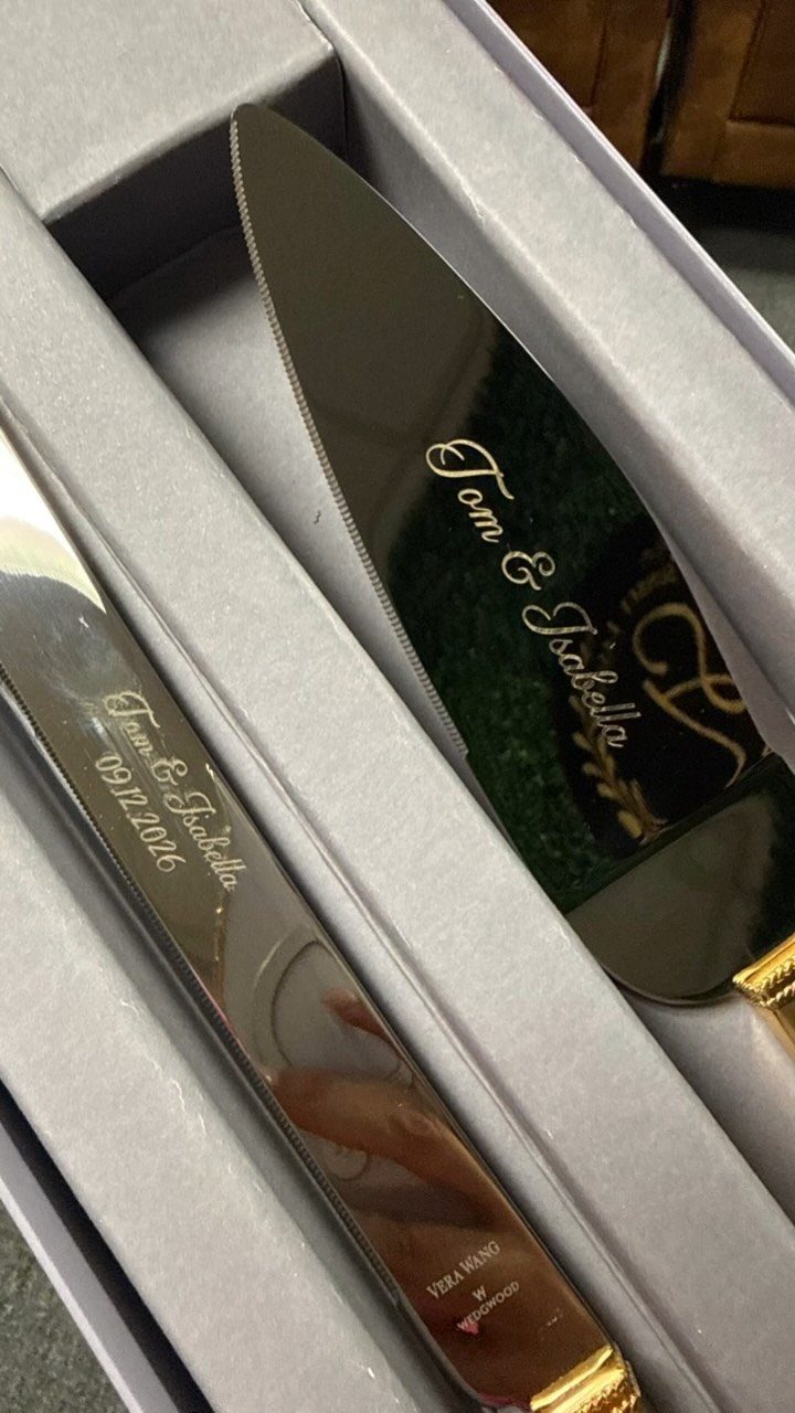 Engraved silver cake knife and server set inside a grey padded gift box.