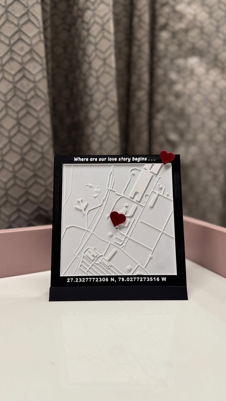 3D white relief map in a black frame with a red heart marker