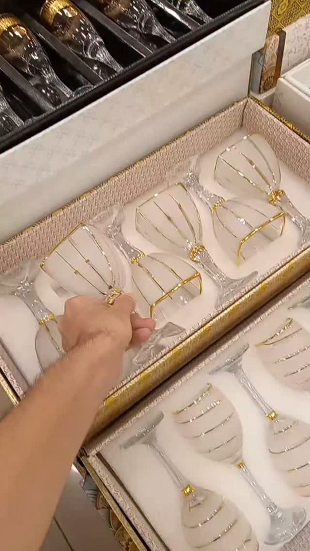 Champagne flutes with gold rims and bands inside a decorative gift box.