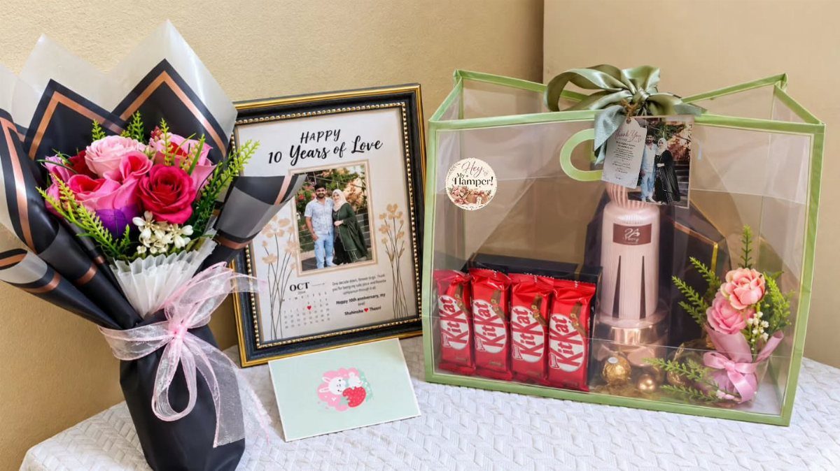 Bouquet of roses, framed anniversary photo, and a gift hamper with chocolates.
