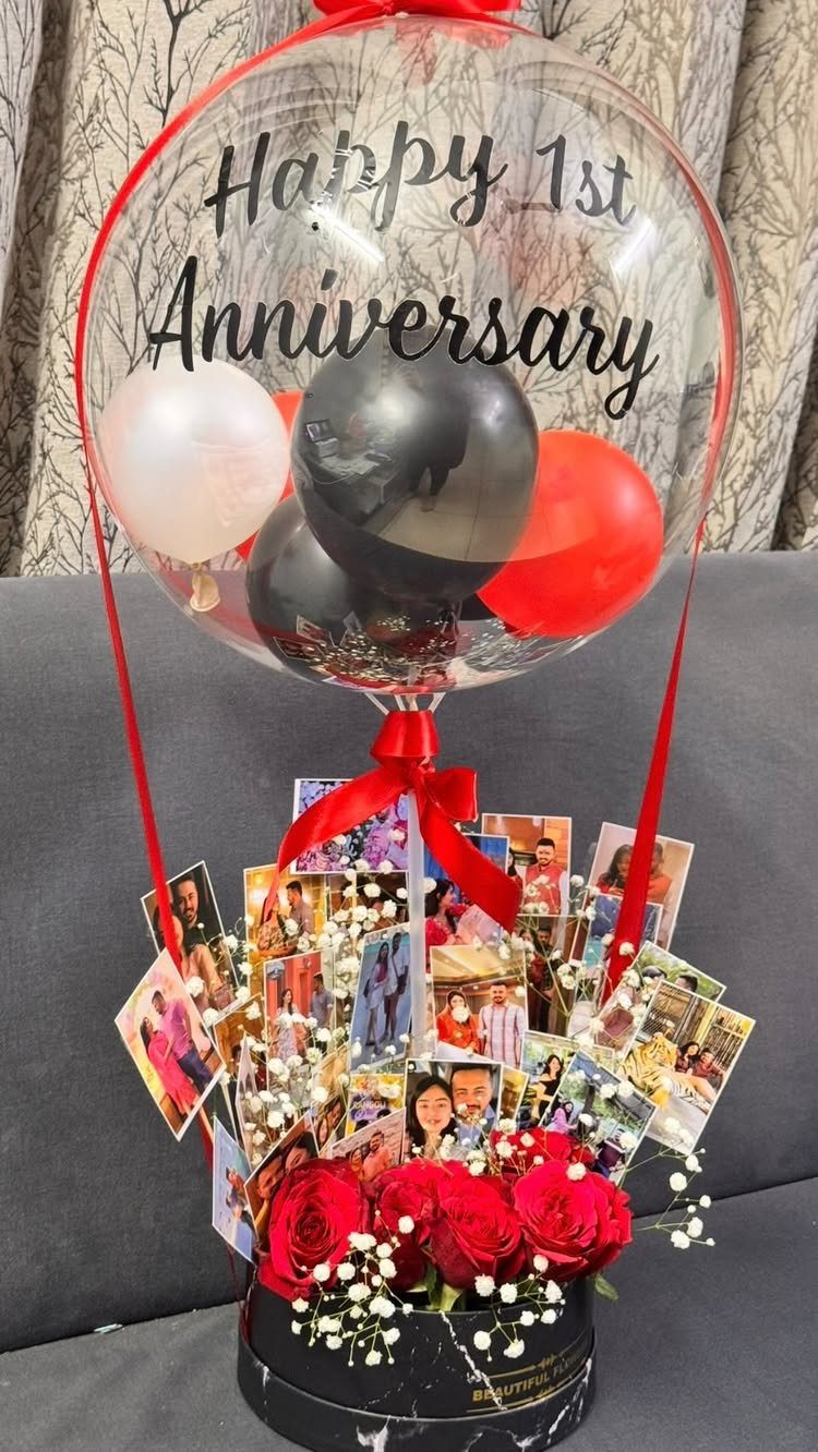Anniversary gift featuring a clear balloon over red roses and personal photographs.