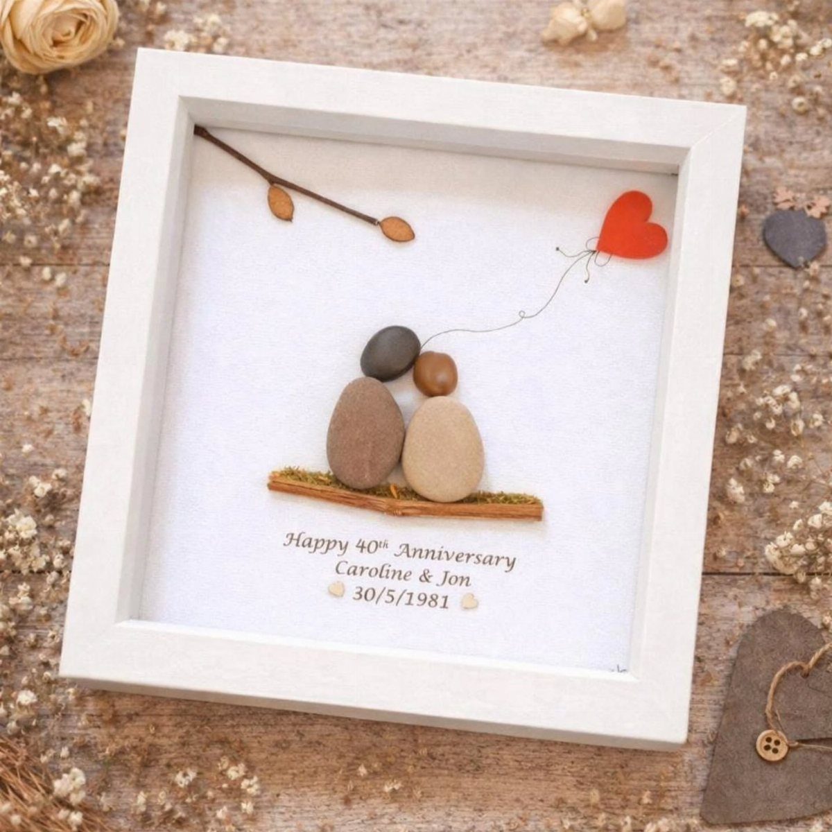 Pebble art of a couple in a white frame for a 40th anniversary.