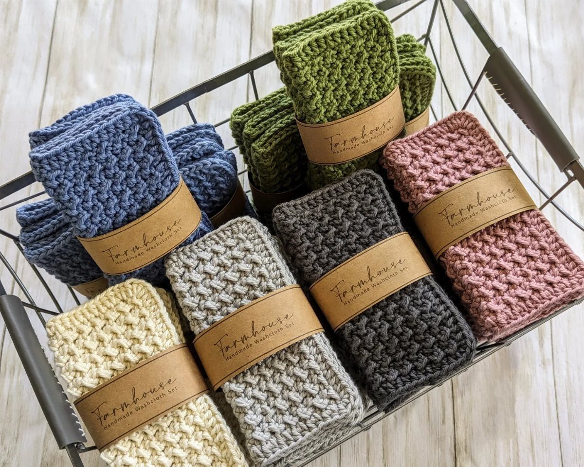 Folded textured cotton washcloths in various colors inside a metal wire basket.