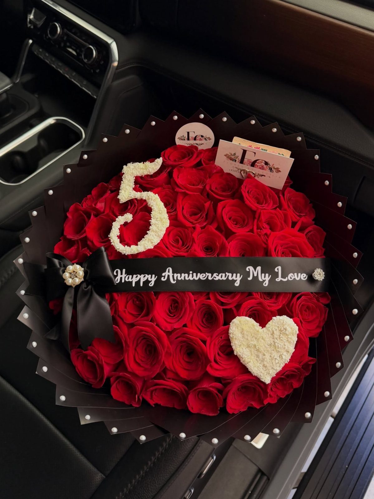 Red rose bouquet with a white floral number five and heart shape.