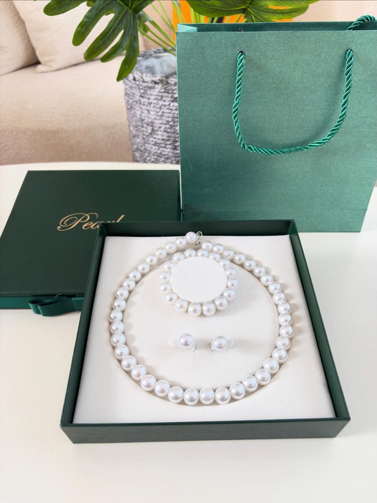 Pearl necklace and earring set in a green gift box with matching bag.