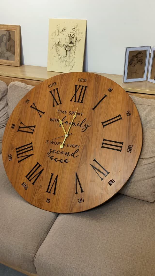 Circular wooden wall clock with family quote resting on a beige sofa