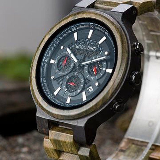 Wooden wristwatch with a dark wood case and matching link strap on a surface.
