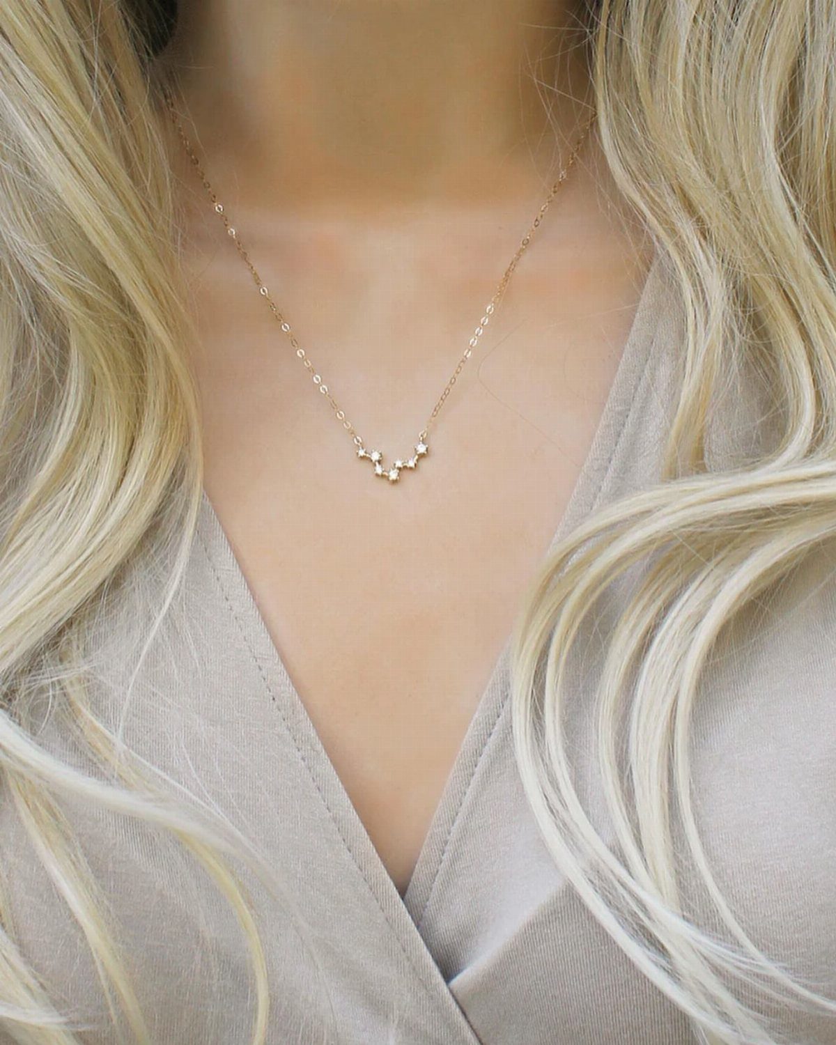 Gold necklace with small sparkling stones worn by a woman with blonde hair