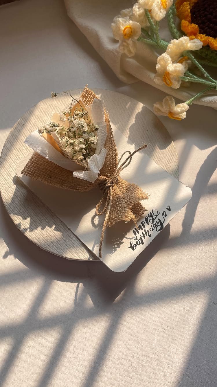 Small dried white flower bouquet wrapped in burlap on a birthday card.