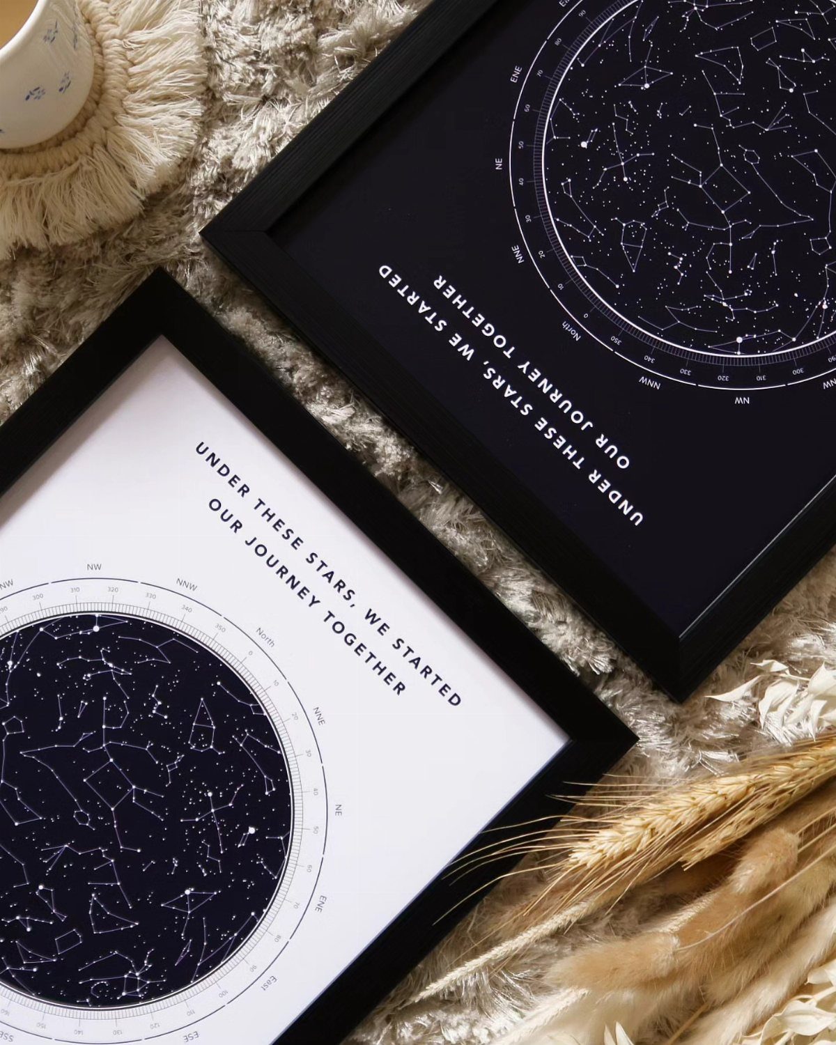 Two framed custom star map prints with romantic text on a beige rug.
