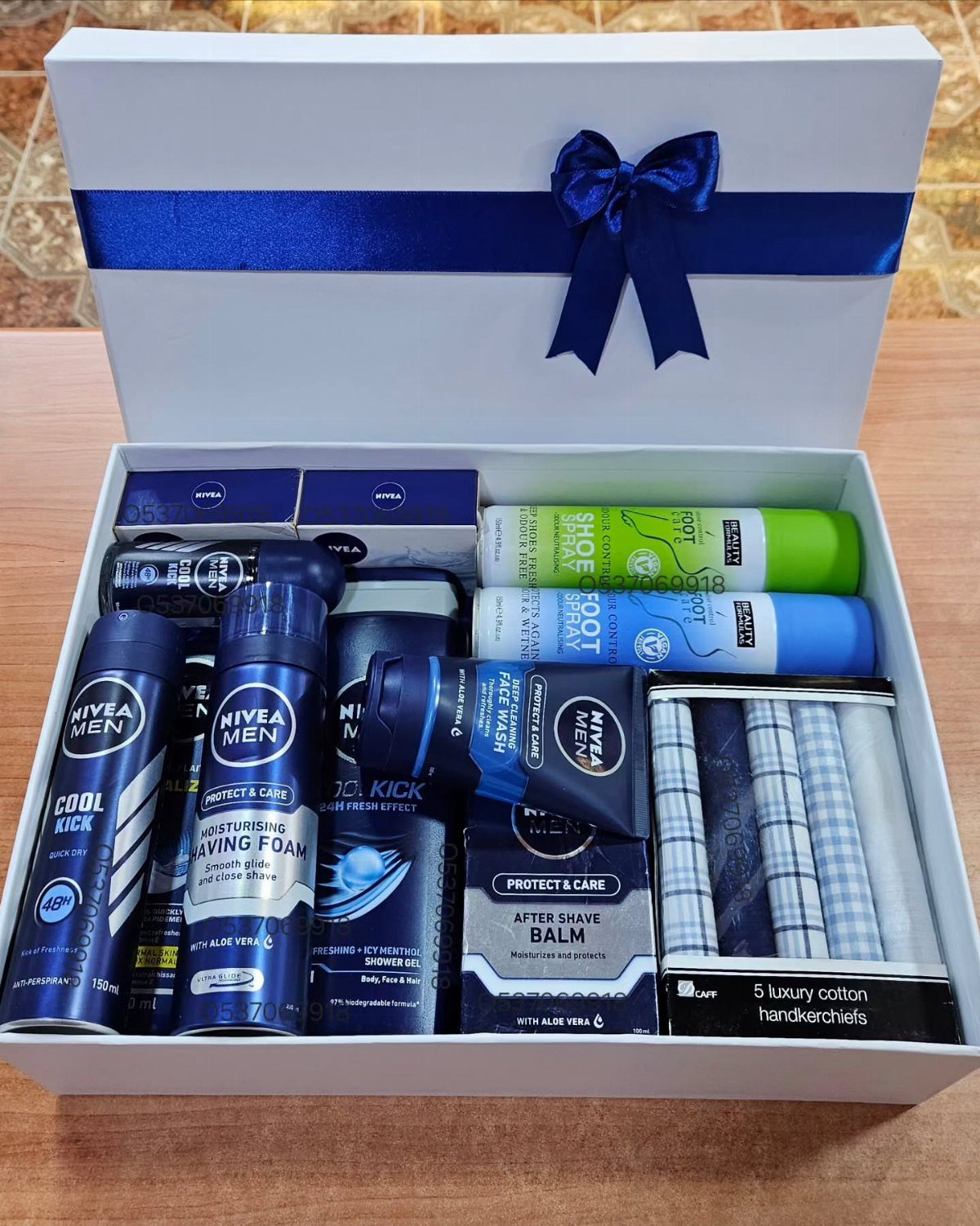 Grooming kit in a white box with blue ribbon containing Nivea Men products.