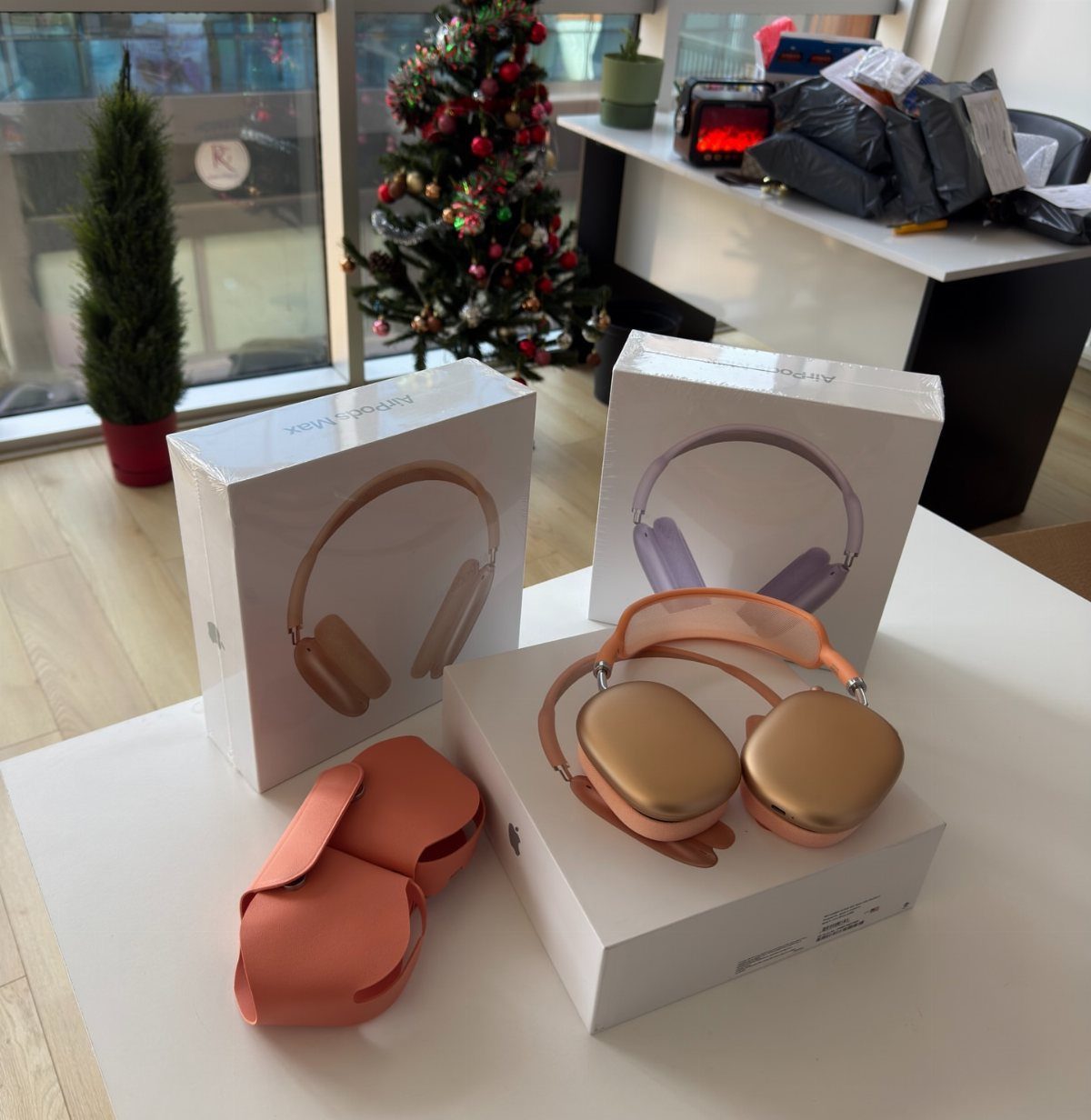 Gold over-ear headphones on a white box next to a Christmas tree