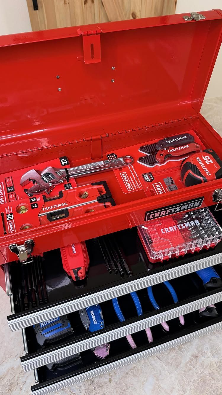 Open red metal tool chest filled with organized hand tools and accessories.