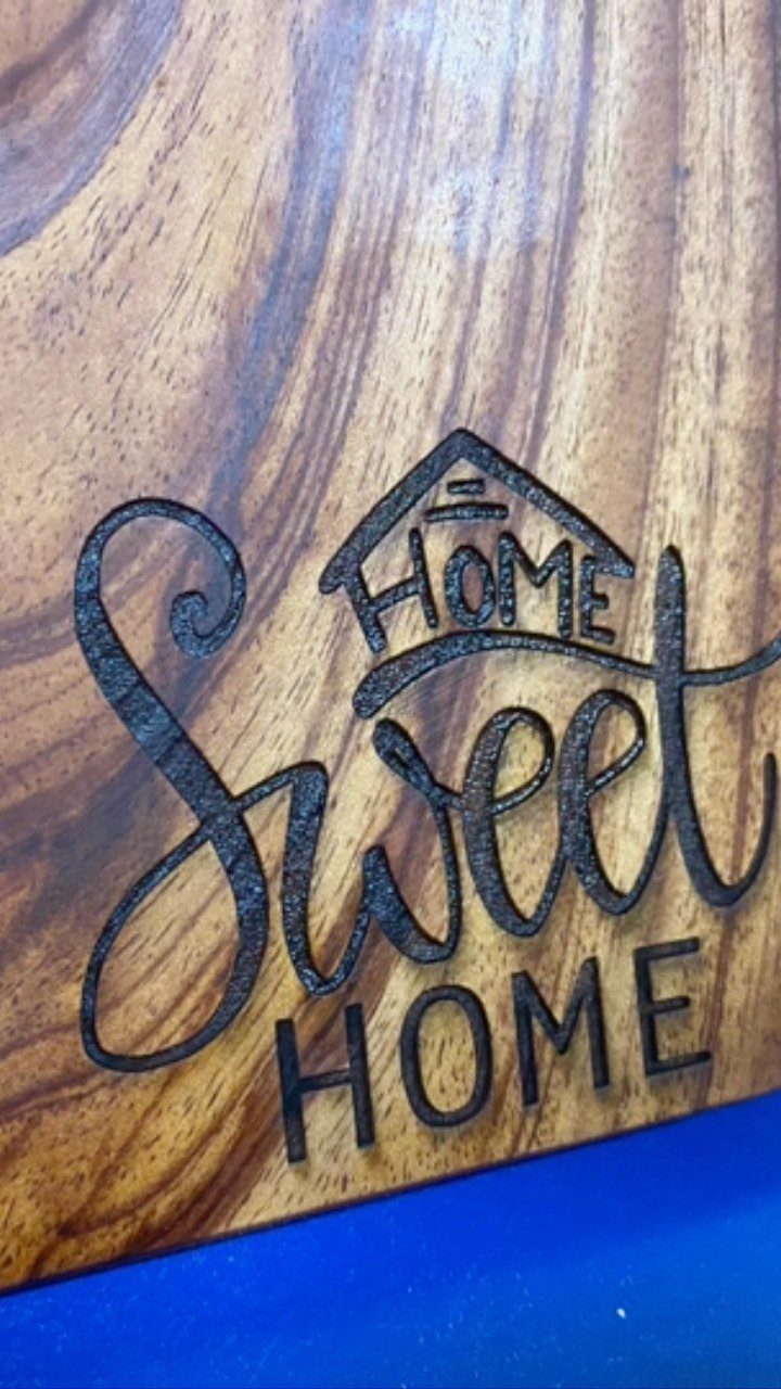 Engraved wooden cutting board with the words Home Sweet Home and a house icon.