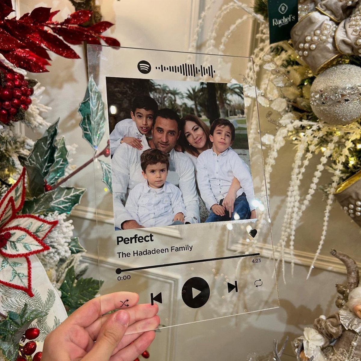 Transparent acrylic music plaque with family photo held near Christmas decorations