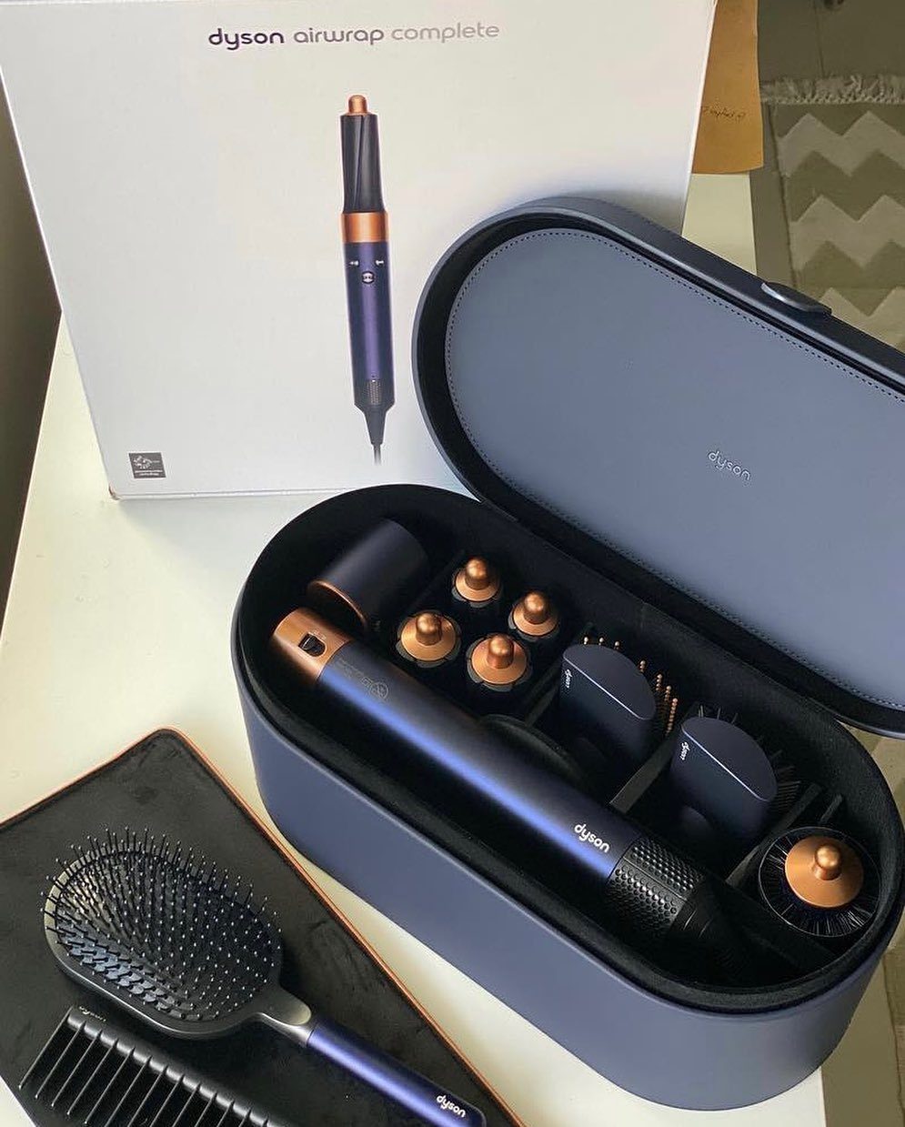 Dyson Airwrap Complete hair styling set in a blue case with matching brush.