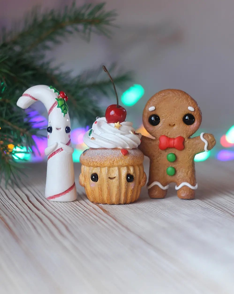 Three cute hand-sculpted clay figures of a candy cane, cupcake, and gingerbread man.