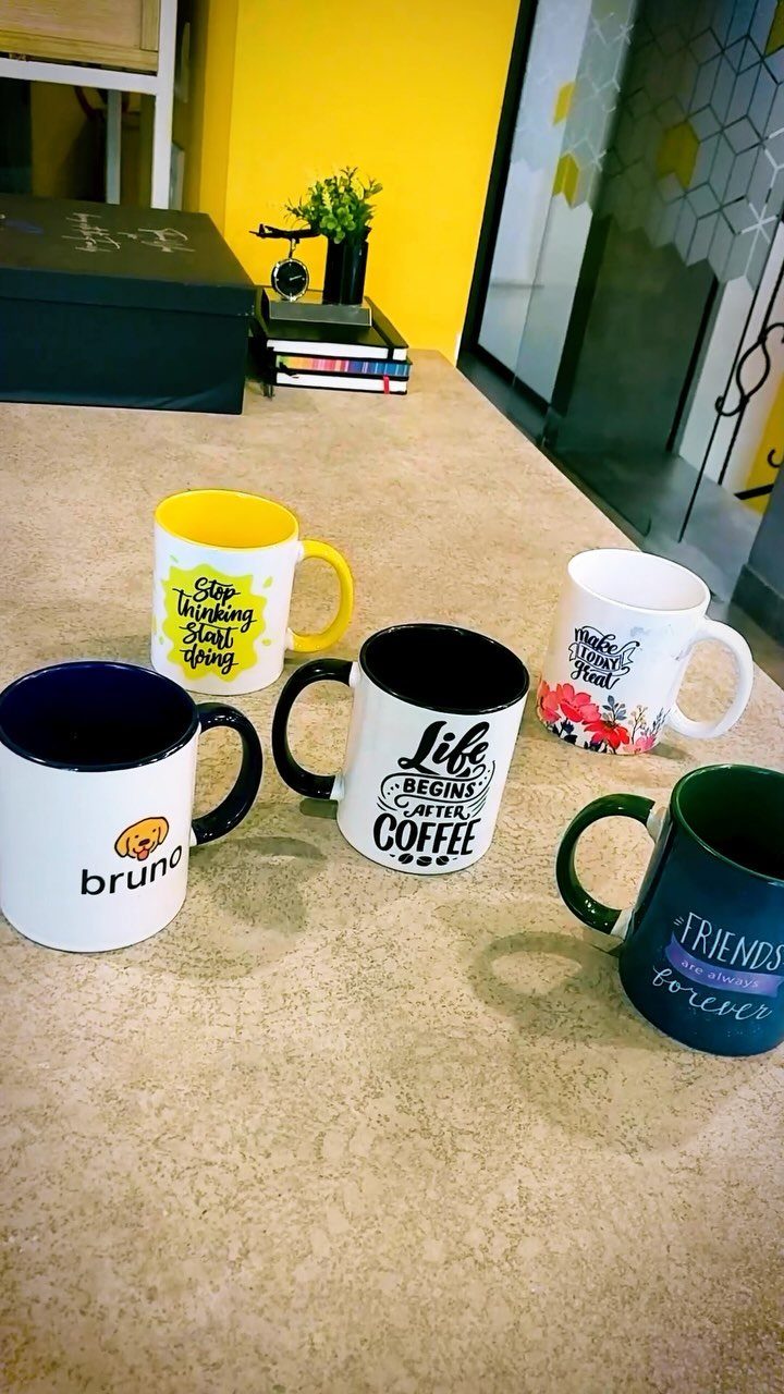 19 Coffee Fan Gifts for Every Budget and Brew Style 17 Five printed coffee mugs with quotes and designs on a light brown table.