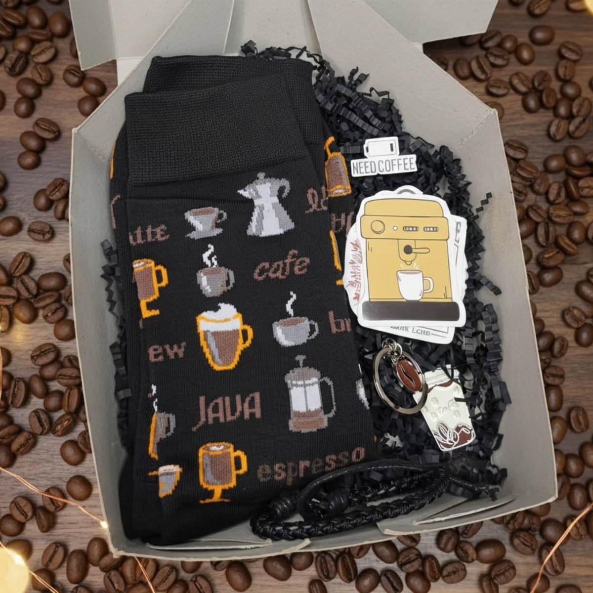 19 Coffee Fan Gifts for Every Budget and Brew Style 8 Black coffee-themed socks and accessories inside a white gift box surrounded by coffee beans.
