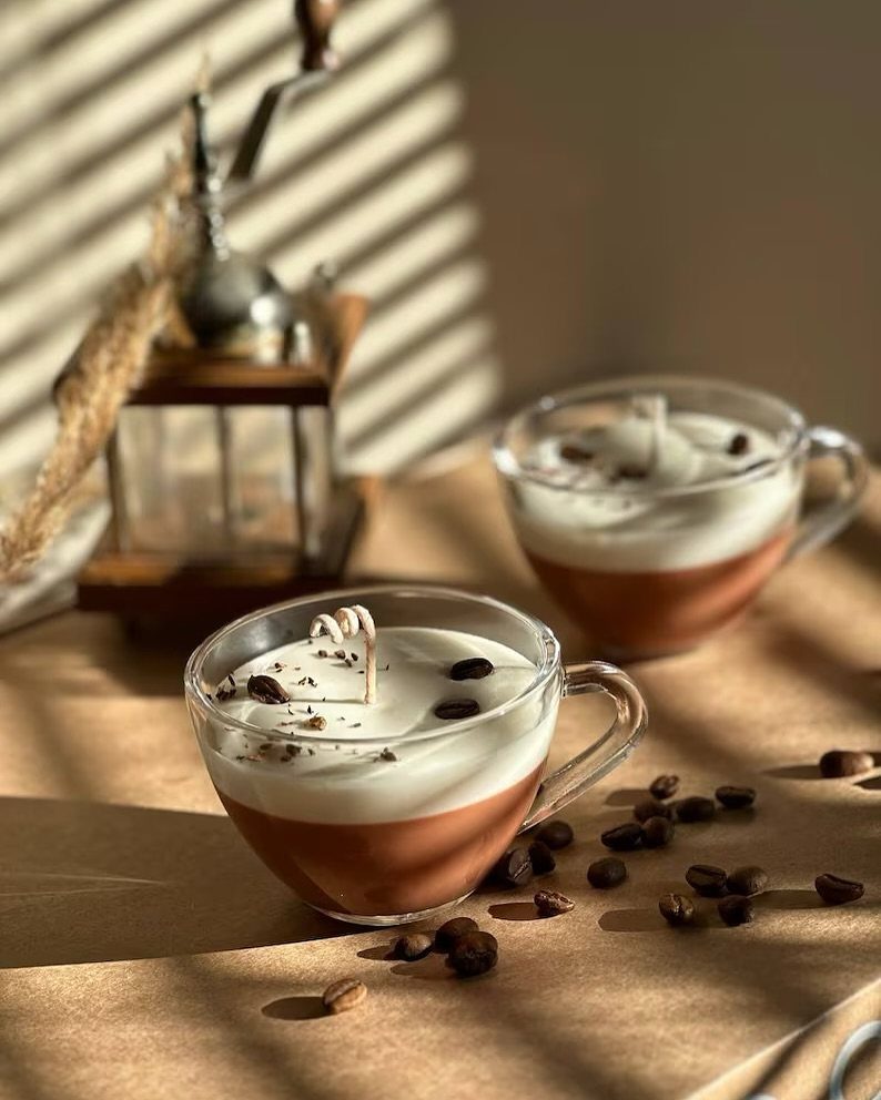 19 Coffee Fan Gifts for Every Budget and Brew Style 3 Coffee-themed candles in glass cups topped with white wax and coffee beans.