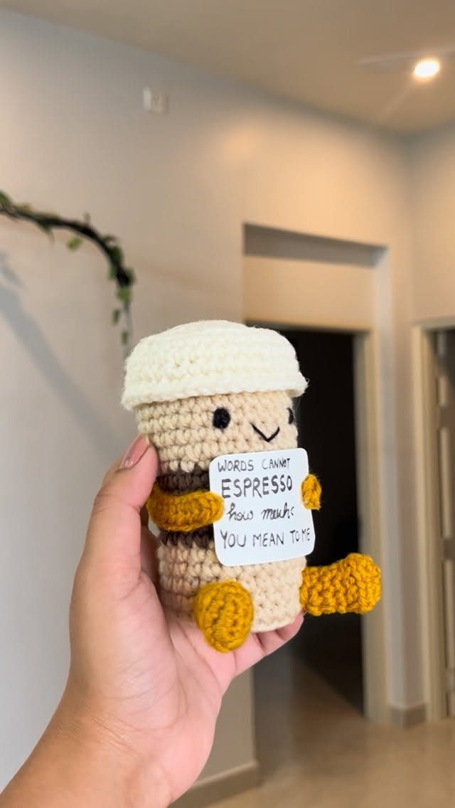 19 Coffee Fan Gifts for Every Budget and Brew Style 10 Crocheted coffee cup plushie with a punny love note held in a hand.