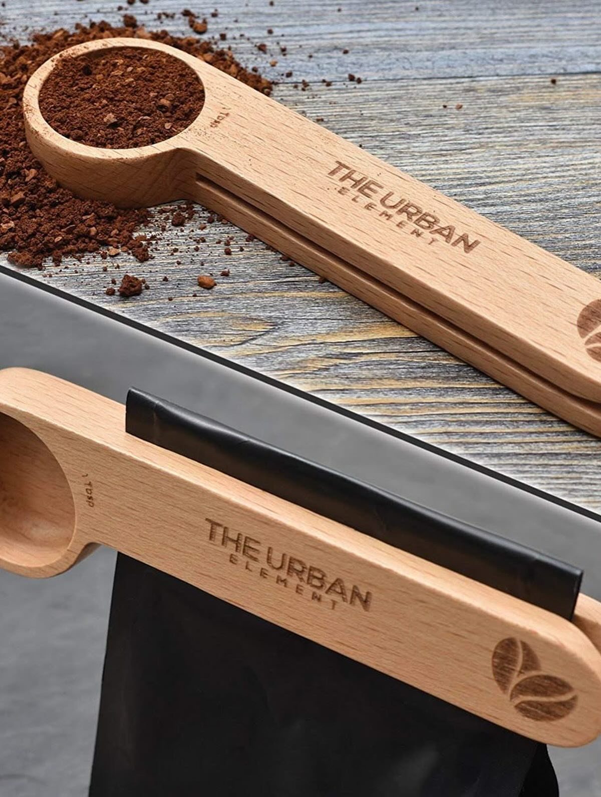 19 Coffee Fan Gifts for Every Budget and Brew Style 16 Wooden coffee scoops with engravings, one filled with grounds and one clipping a bag.