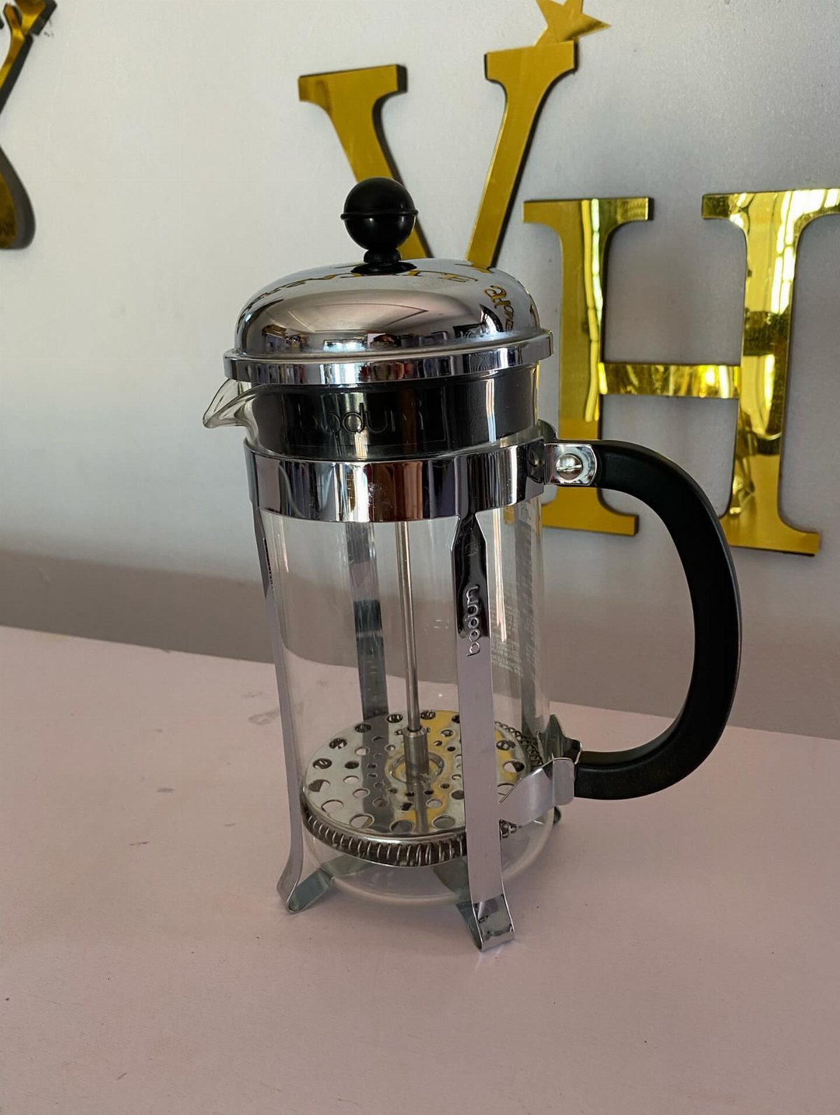 19 Coffee Fan Gifts for Every Budget and Brew Style 13 French press coffee maker with chrome frame and black handle on pink surface