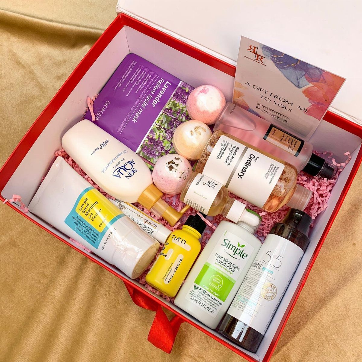 Red gift box filled with skincare products, bath bombs, and a facial mask.