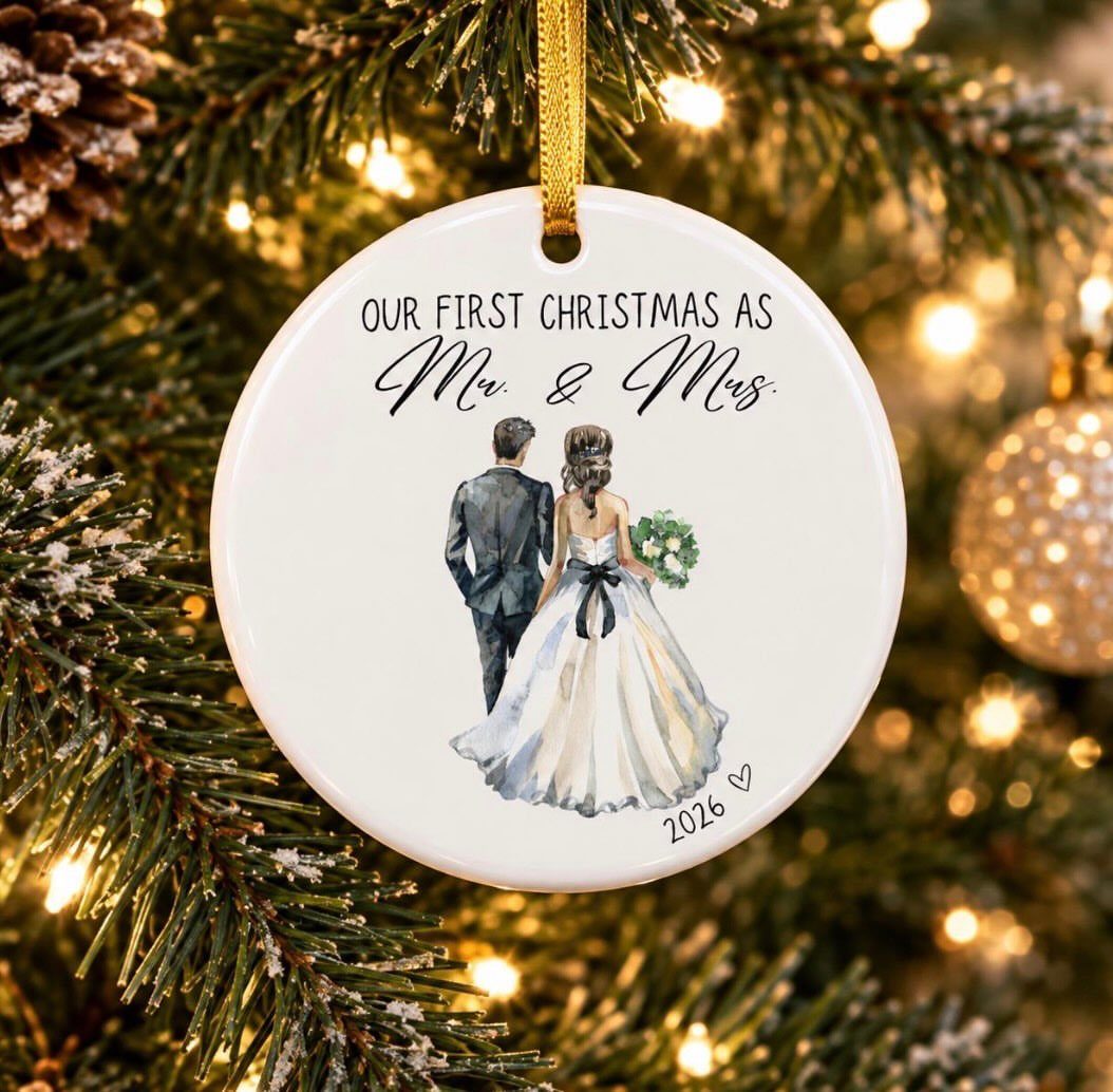 Round white ceramic ornament with a wedding couple illustration hanging on a Christmas tree
