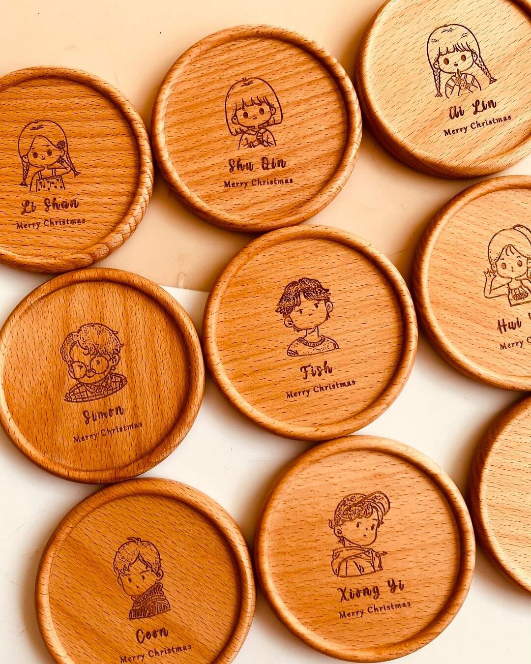 Custom Engraved Gifts: 10 Ideas for Every Occasion 1 Round wooden coasters featuring engraved cartoon portraits and personalized names for Christmas gifts.