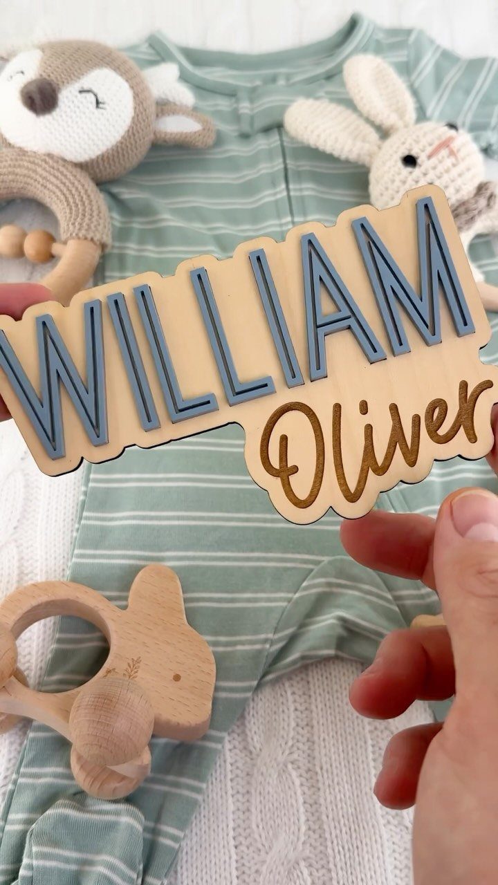 Custom Engraved Gifts: 10 Ideas for Every Occasion 8 Wooden name sign for William Oliver held over baby clothes and toys.