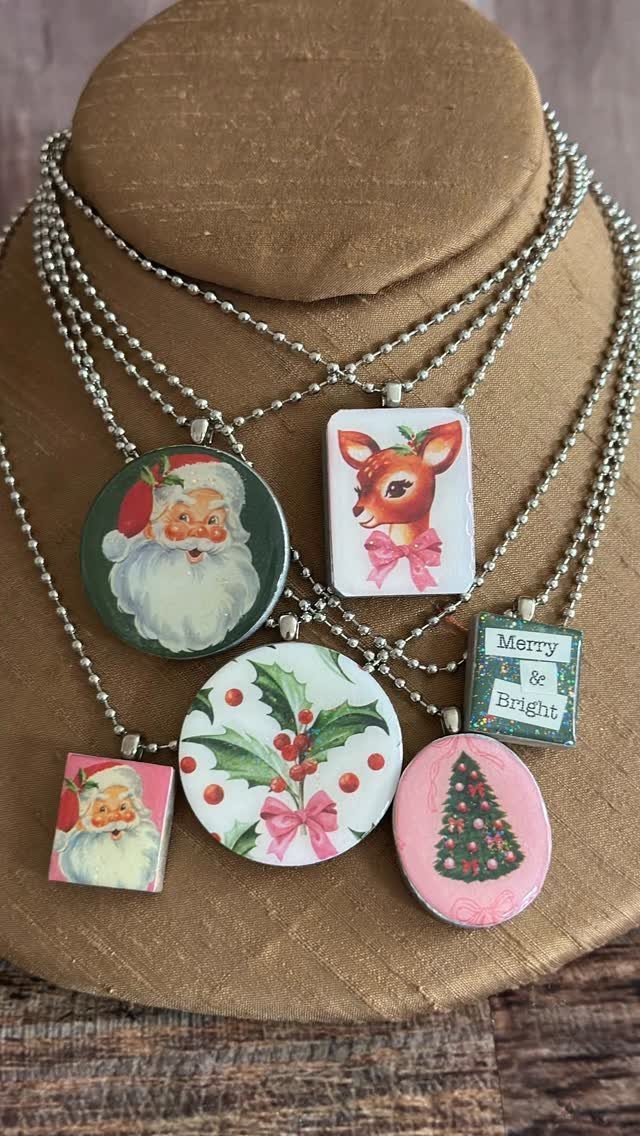 Christmas themed necklaces with Santa and deer pendants on a jewelry display bust