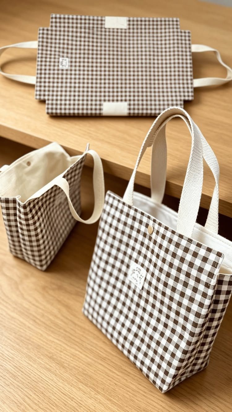 Brown and white gingham checkered fabric tote bags on a wooden table.