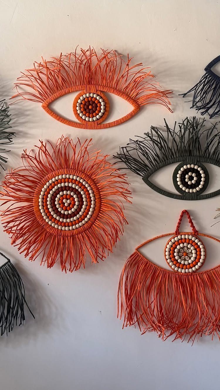 Handmade yarn wall hangings in eye and sun shapes with beaded centers.