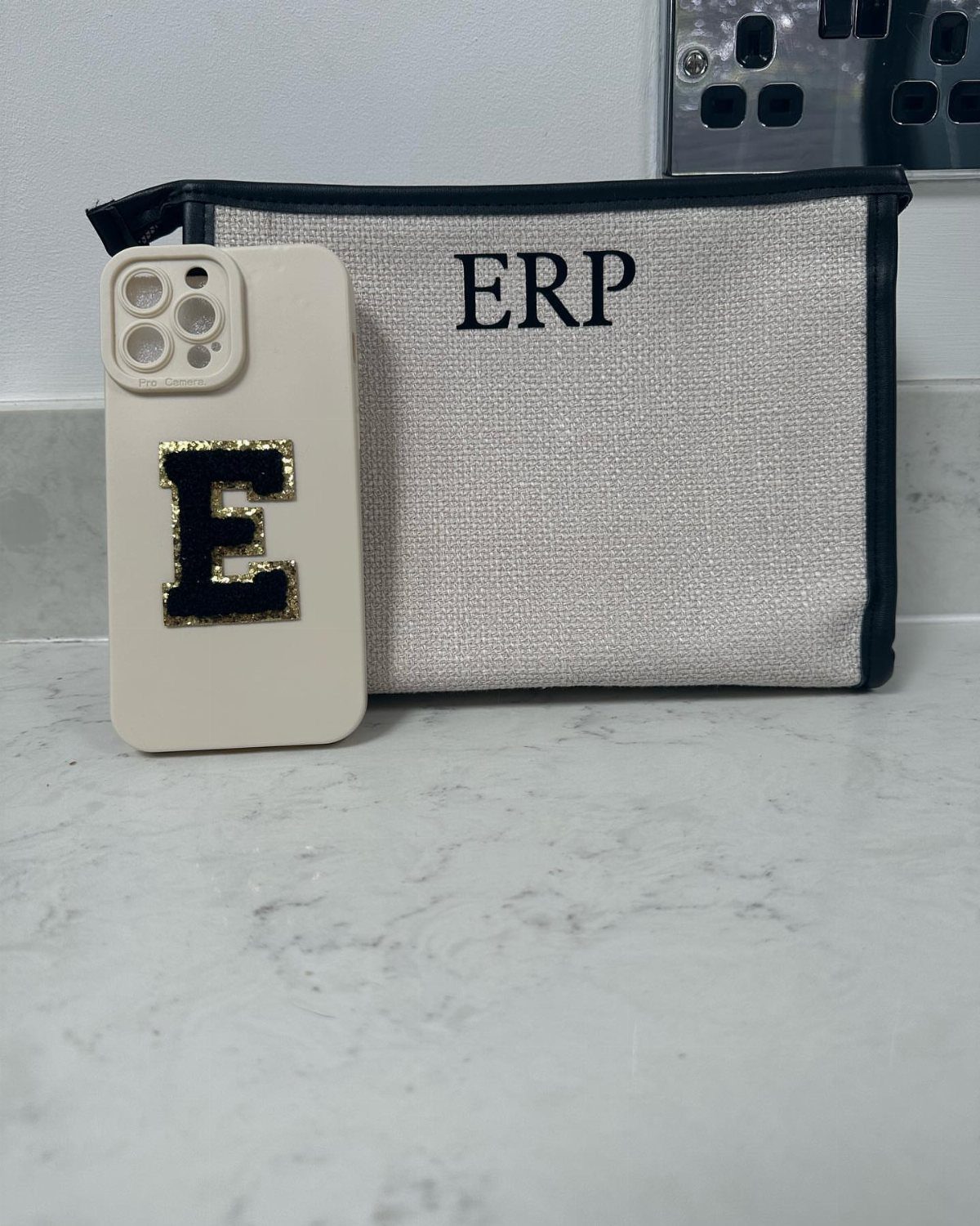 Monogrammed canvas pouch with 'ERP' next to a matching monogrammed phone case.