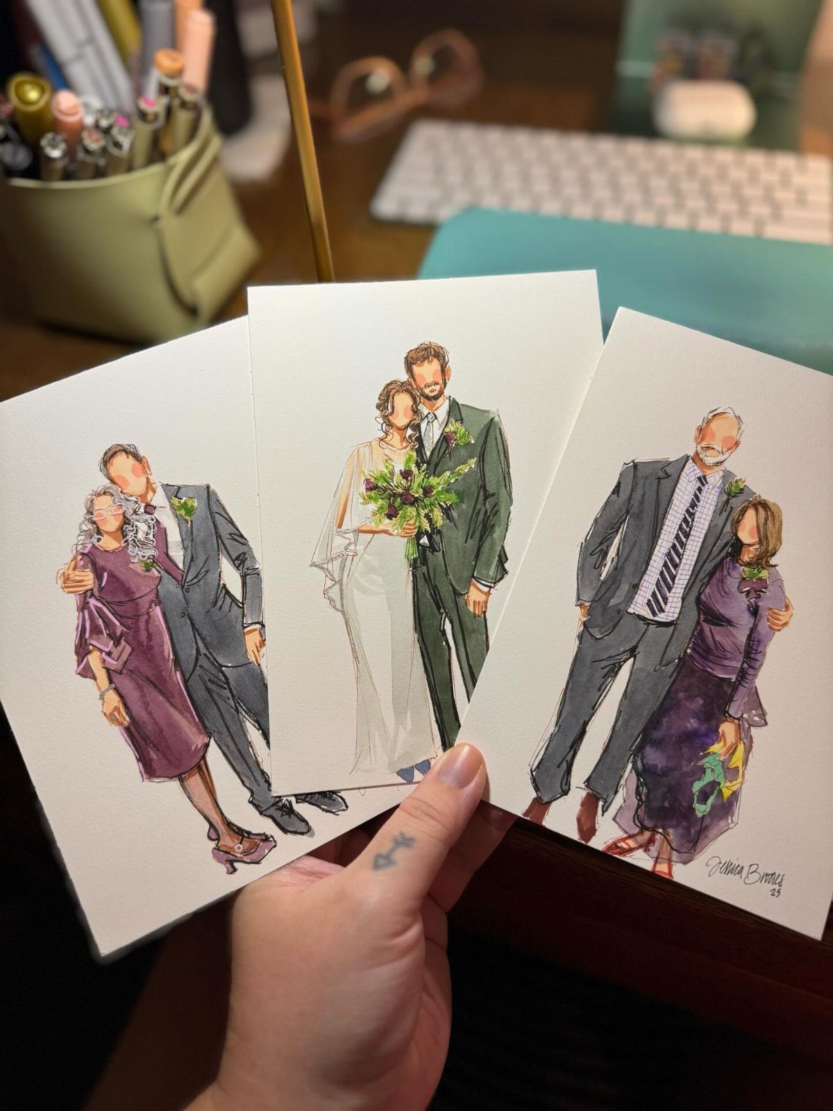 Three watercolor illustration portraits of couples in formal wear held by a hand.