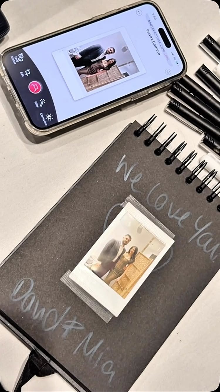 Black spiral notebook with a couple's photo and handwritten names on the cover.
