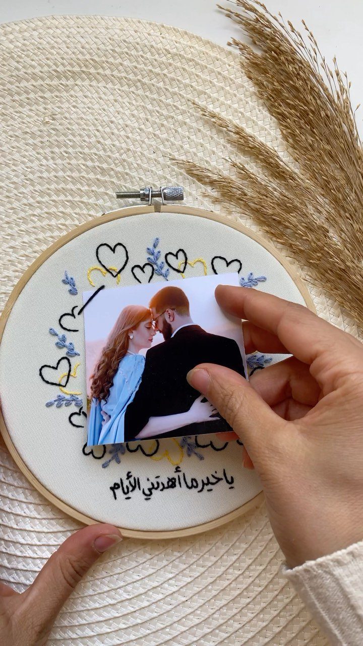 Handmade embroidery hoop with a couple's photo, hearts, and Arabic calligraphy.
