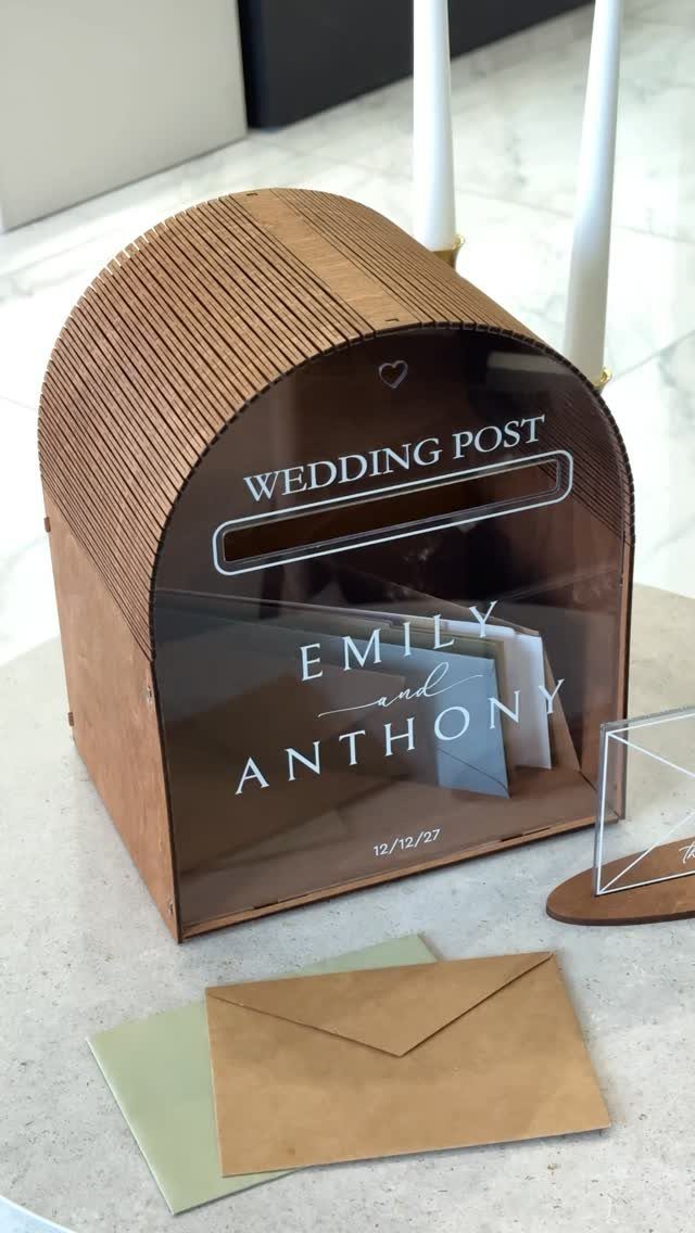 Wooden and acrylic wedding card box with personalized names and date on a table