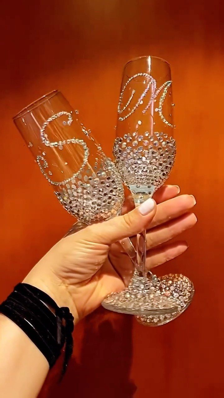 Two champagne flutes decorated with rhinestones and initials S and M.